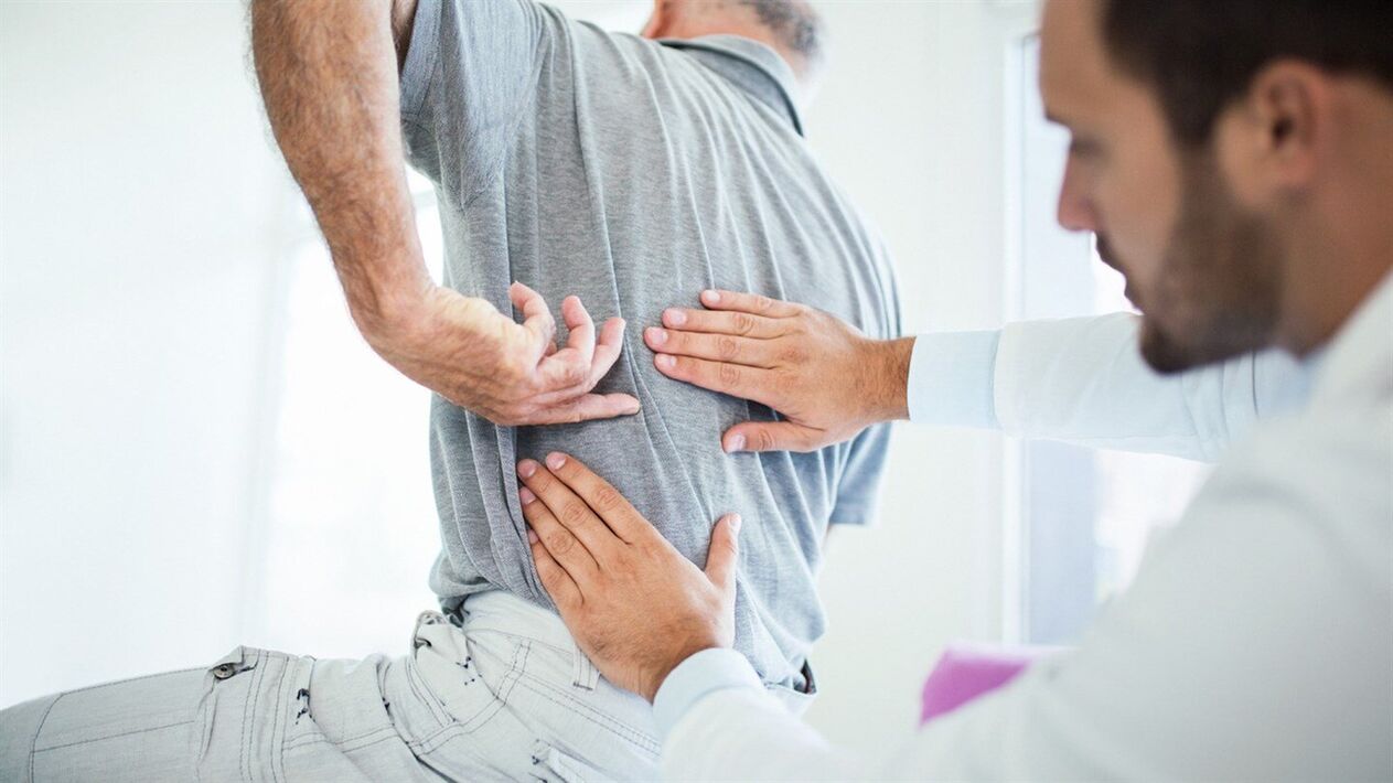 zdravnik pregleda hrbet z ledveno osteohondrozo